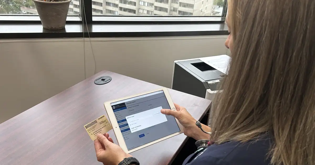 Médecin numérisant une carte RAMQ avec son appareil mobile