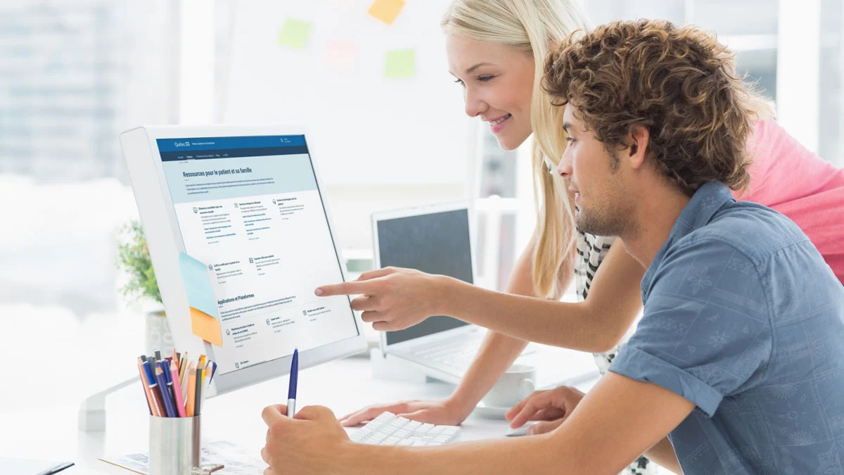 Two colleagues looking at the RQT website on the computer