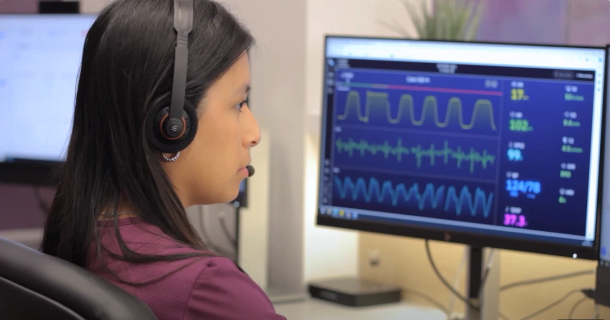 Nurse monitoring a patient's vital signs on a computer screen.