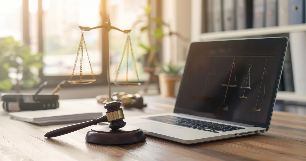 Visuel illustrant la télécomparution grâce à un ordinateur portable et des éléments représentant la justice.