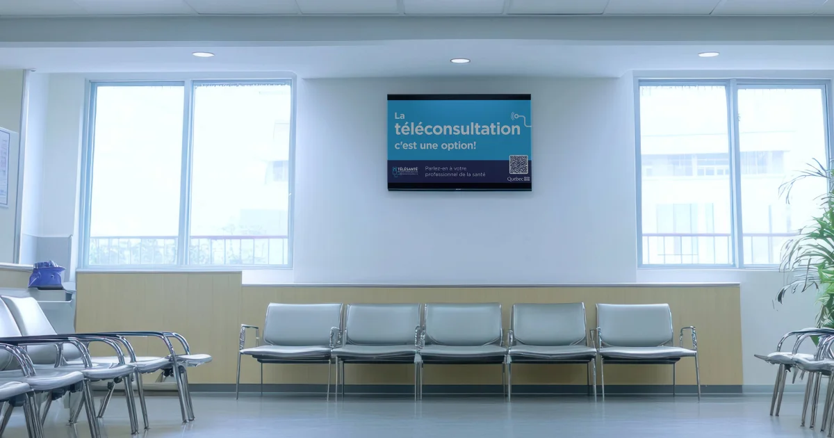 Salle d’attente avec écran mural diffusant l’affiche La téléconsultation, c’est une option! 